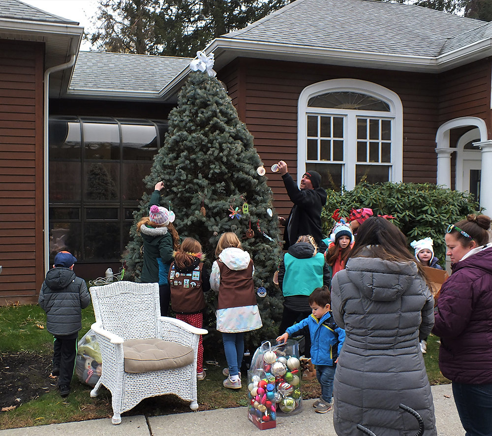 Parents and kids got into decorating the tree outside of the Sarah Hull Hallock Library in Milton.